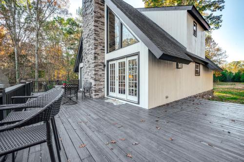 a wooden deck with two chairs and a building at Dock and Hot Tub at High Rock Lake Retreat in Lexington