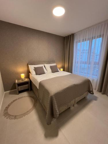 a bedroom with a bed and a large window at TM APARTMENTS Ludwiki in Warsaw