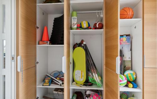 a closet filled with lots of balls and toys at Stunning Home In Ørsted With Sauna in Ørsted