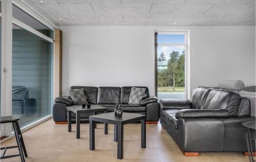 a living room with black leather couches and tables at Stunning Home In Ørsted With Sauna in Ørsted