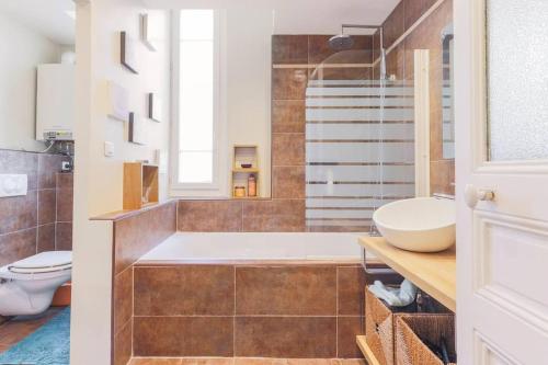 une salle de bain avec une baignoire et un lavabo dans l'établissement Appartement 2 chambres à 15 mn de la mer, à Nice