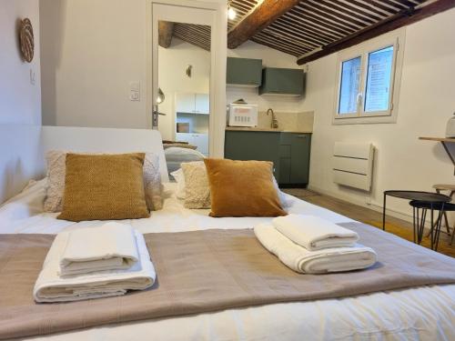 - un grand lit avec des serviettes dans l'établissement Studio lumineux clim - centre ville, à Aix-en-Provence