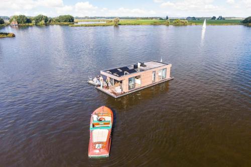 a small boat on a large body of water at Surla houseboat Hangloose Kagerplassen in Buitenkaag