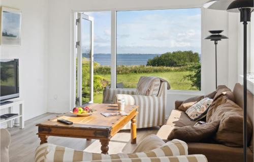 a living room with a table and a view of the ocean at Three-Bedroom Holiday Home In Bandholm in Bandholm