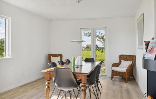 a dining room with a wooden table and chairs at Three-Bedroom Holiday Home In Bandholm in Bandholm