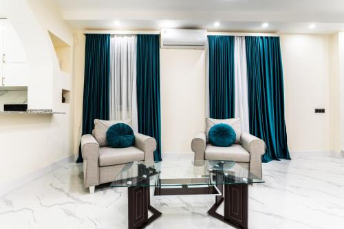 a living room with two chairs and a glass table at Ashtarak Venues in Ashtarak