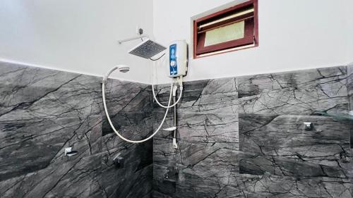 La salle de bains est pourvue d'une douche et d'un ordinateur portable sur le mur. dans l'établissement Hanthana Heights, à Kandy