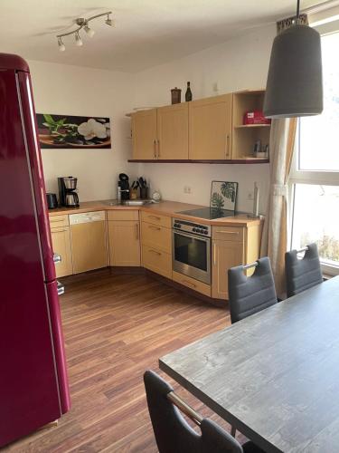 a kitchen with wooden cabinets and a table with chairs at Ferienhaus Scheid in Bremm