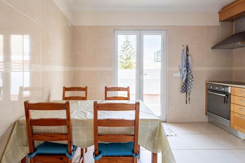 a kitchen with a table and chairs in a kitchen at Baleal Beach Apartment in Baleal