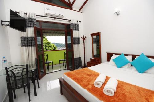 une chambre avec un grand lit et un balcon dans l'établissement Hanthana Heights, à Kandy