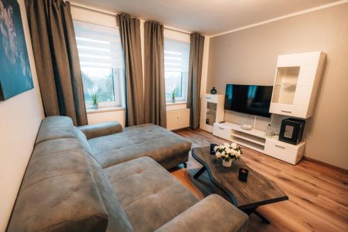 a living room with a couch and a television at Zellerfelder Hof in Clausthal-Zellerfeld
