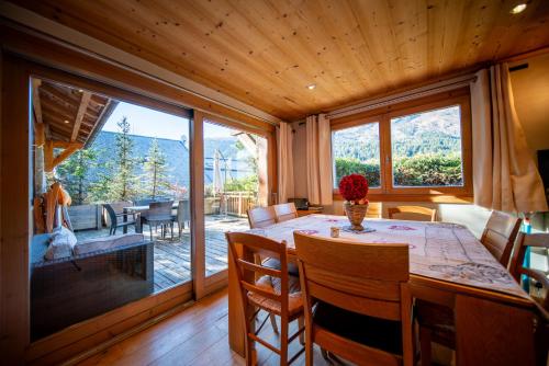une salle à manger avec une table et une grande fenêtre dans l'établissement Appartement de prestige dans chalet Novalsia à Méribel avec sauna, à Méribel