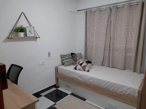 mała sypialnia z łóżkiem i oknem w obiekcie Apartamentos AR Gandía w mieście Puerto de Gandía
