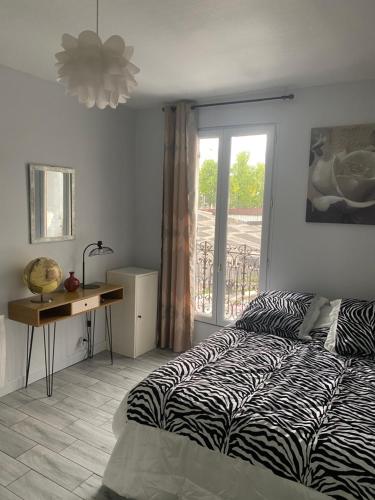 une chambre avec un lit, un bureau et une fenêtre dans l'établissement Charmant appartement 2 pieces à 7 mn de paris, à Aubervilliers