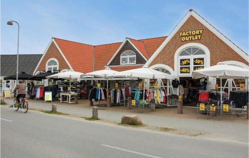a person riding a bike in front of a clothing store at Holiday Home Vandflodvej Blåvand I in Blåvand