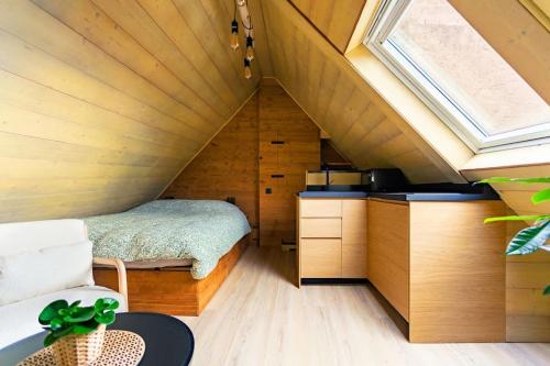 une petite chambre avec un lit dans un grenier dans l'établissement Le petit chalet du centre-ville, à Strasbourg