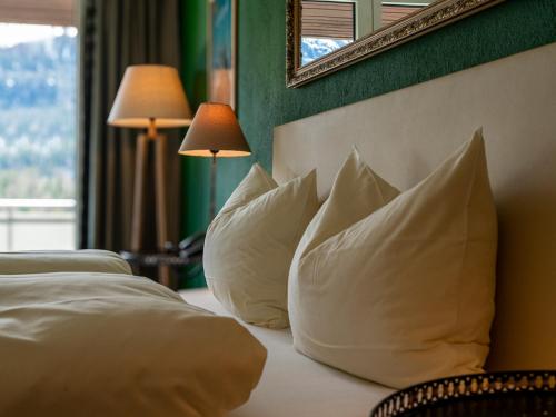 a hotel room with two beds with white pillows at Hotel Europa Suites St Moritz in St. Moritz