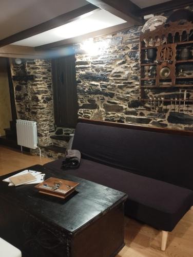 a room with a bench and a stone wall at Casa Mameleiro e Casa Kintal in A Pontenova