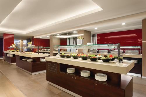 a restaurant with bowls of food on a counter at Ramada Plaza by Wyndham Bucharest Convention Center in Bucharest