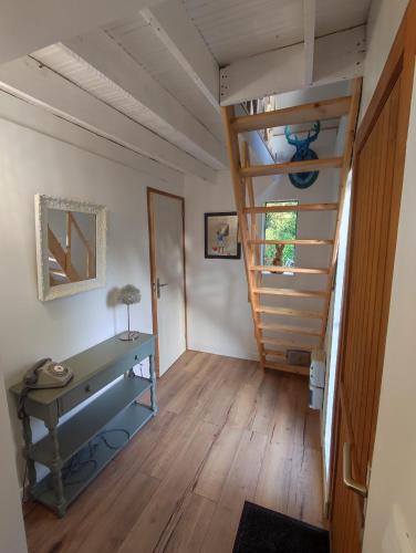 une chambre avec un escalier et une table. dans l'établissement Cabane bleue des Hortillonnages, à Amiens