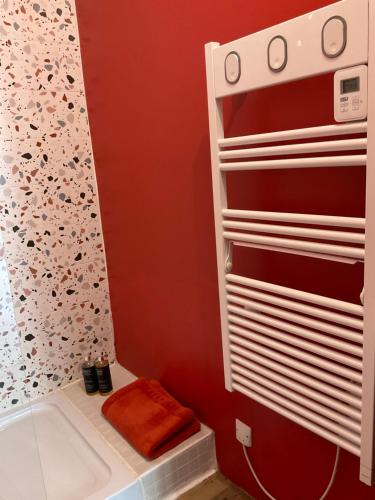 a bathroom with red walls and a shower at Ma pierre à l'édifice, Face à la Cité vue sublime, studio avec terrasse in Carcassonne