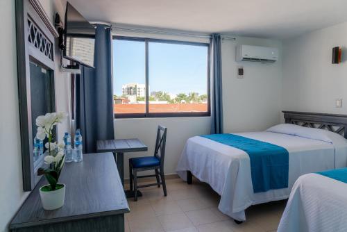 a bedroom with a bed and a table and a window at Hacienda de Castilla in Cancún