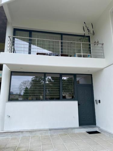 a white house with a black door and a balcony at Cool Loft in Tríkala
