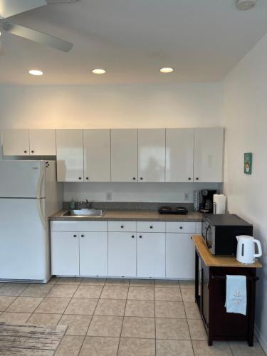 a kitchen with white cabinets and a refrigerator at Sarasota -Walk to Siesta Key Beach in Sarasota