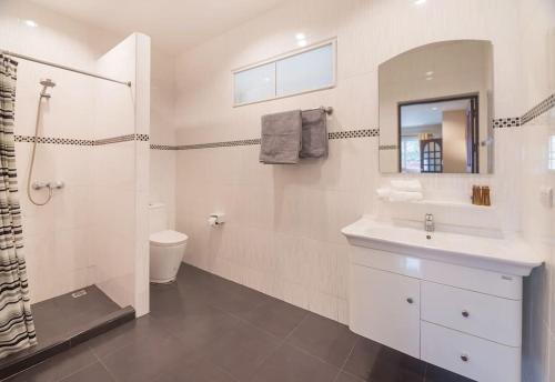 a white bathroom with a sink and a shower at Villa Waleree in Pattaya South