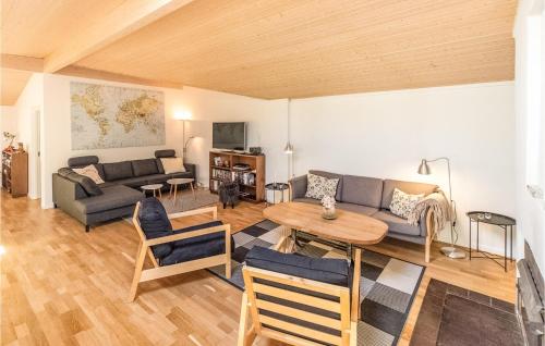 a living room with a couch and a table at Five-Bedroom Holiday Home In Hojby in Højby