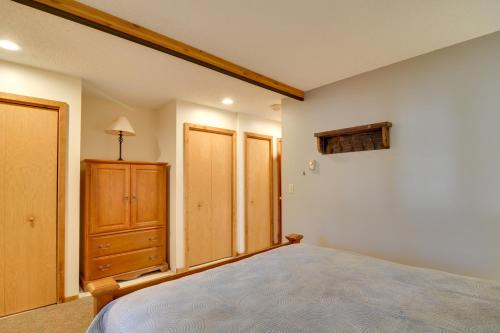 a bedroom with a bed and a wooden cabinet at Schuss Mountain Resort Condo Steps to Golf! in Mancelona