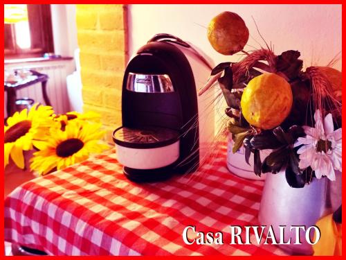 a coffee maker sitting on top of a table with flowers at Casa RIVALTO - Antiche Dimore Pisane in Rivalto