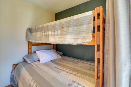 a bedroom with a bunk bed with a bedspread at Schuss Mountain Resort Condo Steps to Golf! in Mancelona