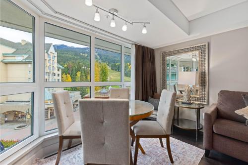 a dining room with a table and chairs and a large window at Le Chamois by Whistler Premier in Whistler