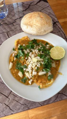 Un plato de comida con un tazón de comida con un pan en Georgies wooden homes stay, en Goa