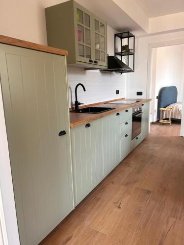 a kitchen with white cabinets and a wooden floor at Casa Matilde in Sanremo