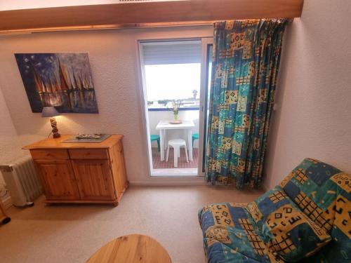 un salon avec un canapé, une table et une fenêtre dans l'établissement Grand studio, PISCINE, Vue magnifique plage, 4 personnes, secteur Allée des Arts Le Lydia, au Barcarès