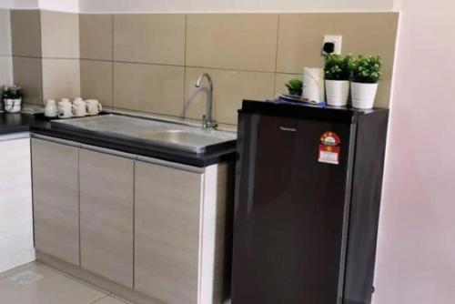 a kitchen with a sink and a refrigerator at ROMANCE FULL HOUSE THREE PREMIER SUITE in Butterworth