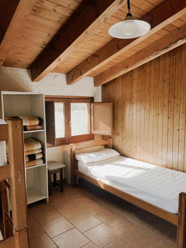 a bedroom with two beds in a wooden wall at Alberg rural torre del baró in Sant Llorenc de Morunys