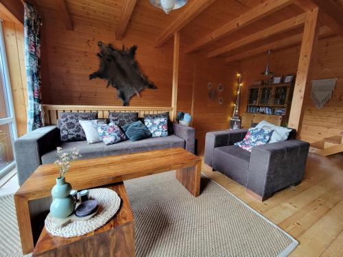 a living room with two couches and a table at Chatka Beskidzka in Targanice