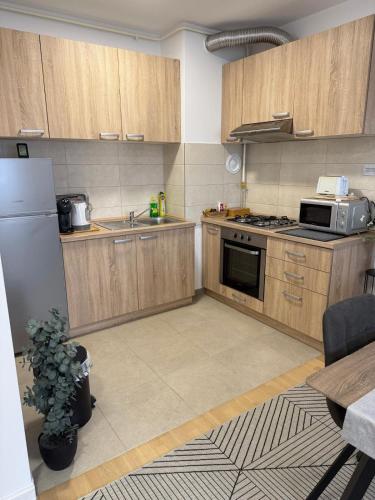 a kitchen with wooden cabinets and a white refrigerator at FIOLICA in Zaprešić