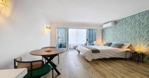 une chambre avec un lit, une table et une fenêtre dans l'établissement Hippocampe - Studio - 100m Croisette - Climatisé - Centre, à Cannes