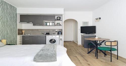 une chambre avec un lit et une cuisine avec un lave-linge dans l'établissement Hippocampe - Studio - 100m Croisette - Climatisé - Centre, à Cannes