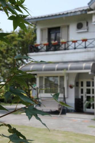 a white house with a balcony on top of it at Maple in Wujie