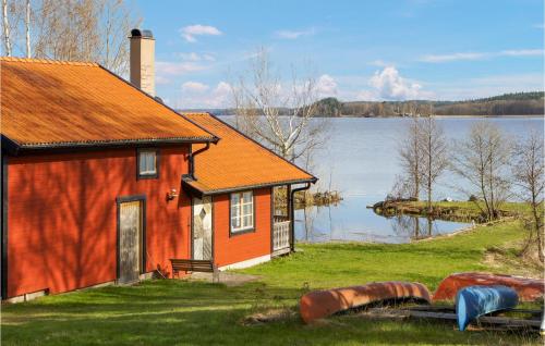 an orange house next to a body of water at Amazing Home In Strängnäs With Sauna in Aspö