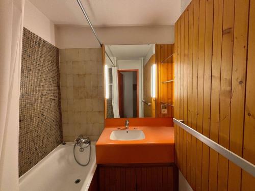 La salle de bains orange est pourvue d'un lavabo et d'une baignoire. dans l'établissement Studio skis aux pieds, 4 pers, balcon sud, cœur des Menuires - FR-1-452-185, aux Menuires