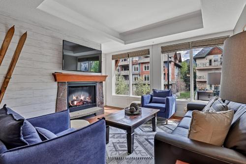 een woonkamer met banken en een open haard bij Classic Hideaway Elegant 2BD 2BTH in Canmore
