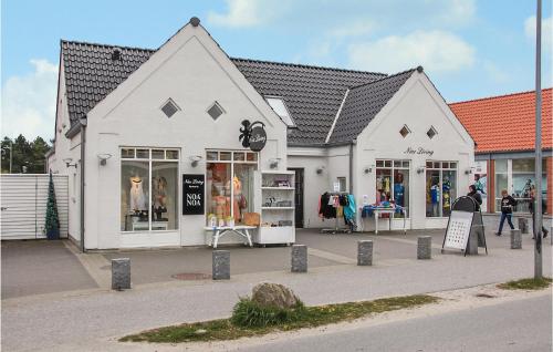 a white building with stores on the side of a street at Holiday Home Per Knoldsvej Blåvand Ii in Blåvand