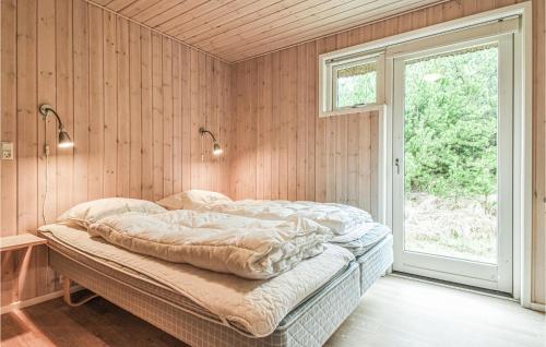 a bedroom with a bed in a room with a window at Holiday Home Per Knoldsvej Blåvand Ii in Blåvand