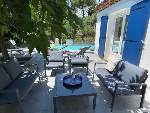 une terrasse avec des chaises, une table et une piscine dans l'établissement Les Saquedes 48, à Sainte-Maxime